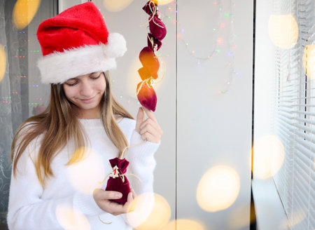Child girl open small bags of gifts surprises advent calendar in her hands. Happy waiting Christmas and New Year.の写真素材