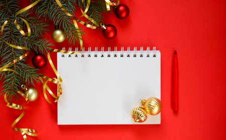 New Year goal list 2022. Clean notebook for writing about plan listing of new year goals and resolutions setting on red background with Christmas tree and red glitter ball and gold ribbon. Wish list.の写真素材