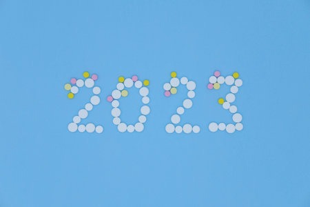 White medical pills in the form of number 2023 on a blue background close up. Christmas medical flatlay.の写真素材