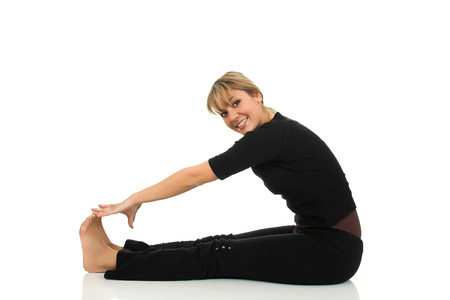 Young beautiful girl stretching on the floor isolated on white backgroundの写真素材