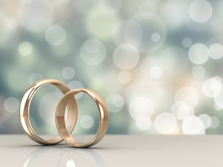 A pair of gold wedding rings with bokeh backgroundの写真素材