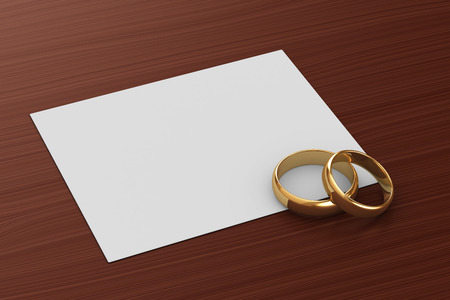 A pair of gold wedding rings and a cardの写真素材