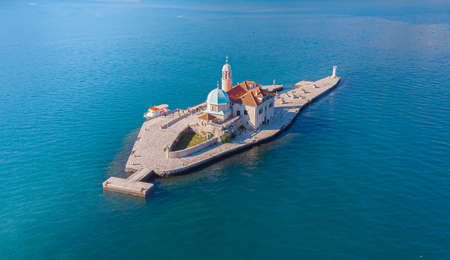 Seascape with drone of the artificial island of the Church of Our Lady of the Rocks during a summer day with a beautiful turquoise water on the shores of Perast in Kotor Bay, Montenegroの写真素材