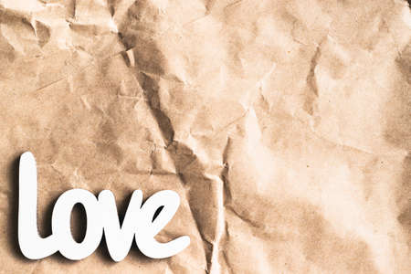 The inscription love made of wood on a crumpled paper bag.の写真素材