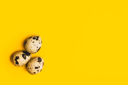 Quail eggs on a yellow background. Products for diet and healthy eating.