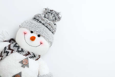 Snowman on a white background. Toy snowman in a knitted hat and scarf.の写真素材