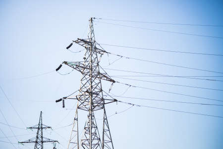 Metal supports of electric transmission lines on a blue sky background.の写真素材