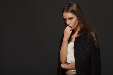 Portrait of one beautiful young sexual woman with long eyelashes lush hair holding hands near face...