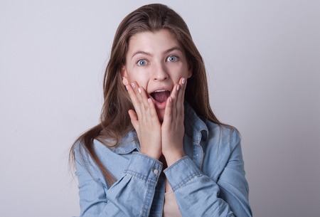 Young European attractive sexy fashion model with long blond natural hair, beautiful eyes, full lips, perfect skin is posing in jeans and shirt in studio for glamour vogue test photo shootの写真素材
