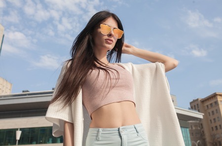 Portrait Of Young Beautiful Woman. beautiful young brunette fashion model posing outdoor. Summer outdoor portrait. Focus on woman, blurred background.の写真素材
