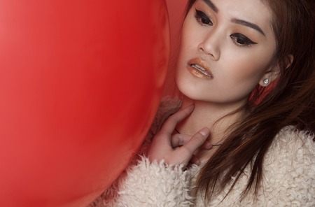 Young asian attractive sexy fashion model with long blond natural hair, beautiful eyes, full lips, perfect skin is posing in studio for glamour vogue test photo shootの写真素材