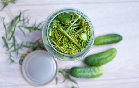 Jar with cucumbers. Conserve with vegetables on home table.の写真素材