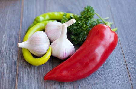 Chili pepper and flavoring herbs on wooden tableの写真素材