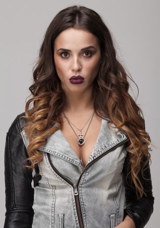 Sexy woman with big boobs in jeans coat. Full purple lips and long curly hair.の写真素材