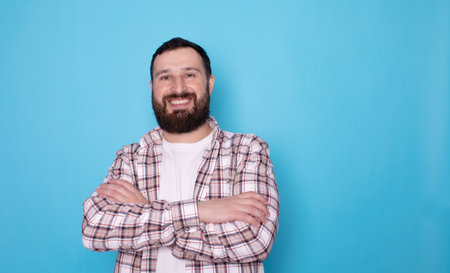 Portrait of a handsome young man with a beard on a blue backgroundの写真素材