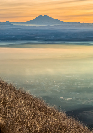 Mountains in the fog, haze. The Main Caucasian Range. Multicolored background. Mountains at sunset. Winter fog.の写真素材