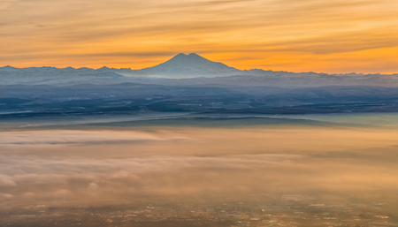 Mountains in the fog, haze. The Main Caucasian Range. Multicolored background. Mountains at sunset. Winter fog.の写真素材