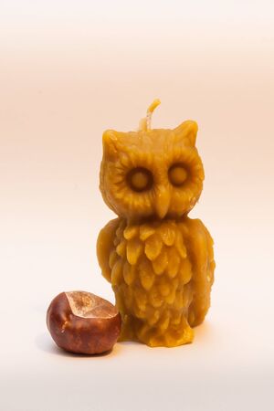 Candle in the shape of an owl, from beeswax, on white backgroundの写真素材