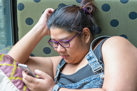 Good spending time. Confident young woman holding mobile phone while sittingの写真素材