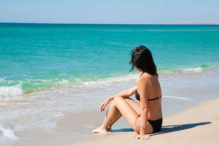 Girl sitting on the beachの写真素材