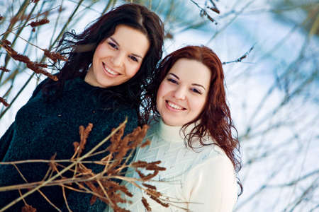 Girls twins near river in winterの写真素材