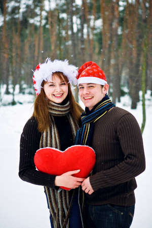 Couple in love with a red heart and Christmas Hatsの写真素材