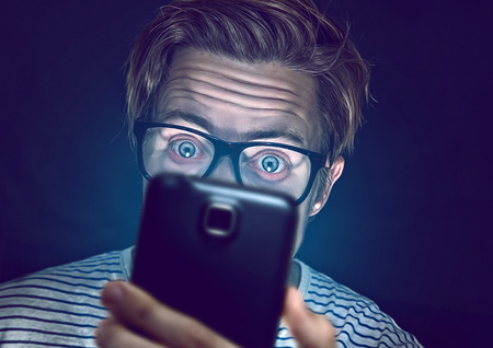 Young man addicted with his smartphone