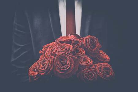 Man offers a bouquet of rosesの写真素材