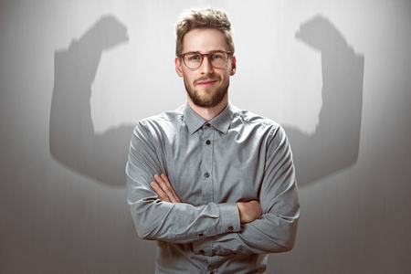 Smiling Businessman with muscular shadow armsの写真素材