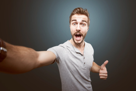 Young handsome man taking a selfie photoの写真素材