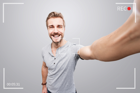 Handsome man takes a video of himselfの写真素材