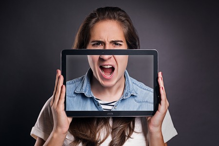 Match half faces with a tablet screen while angryの写真素材