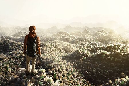 Man stands on top of plastic waste mountainsの写真素材