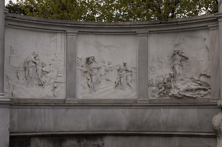 A collection of figures on a carved stone wall in Vienna Europaの写真素材