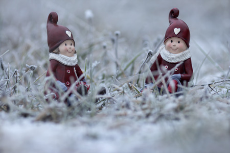 Two christmas figures in the frosty grassの写真素材