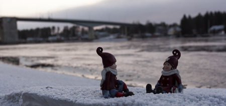 Two figures on an ice block infront of a bridge in the winterの写真素材