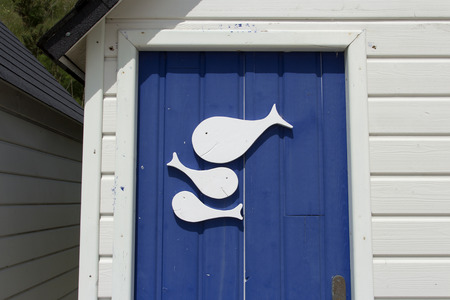 A detail photo of fishes on a door on a beach cabin in Franceの写真素材