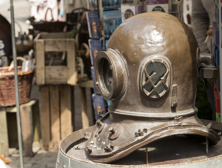 An old divers helmet outside a shop to attract customersの写真素材