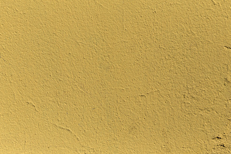 A grained yellow concrete wall with textureの写真素材