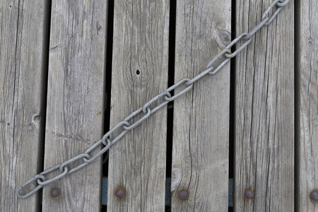 A jetty wtih a chain laying on it in a diagonal line.の写真素材