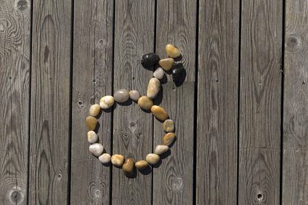 A set of pebbles on a wooden pier forming the mars symbolの写真素材