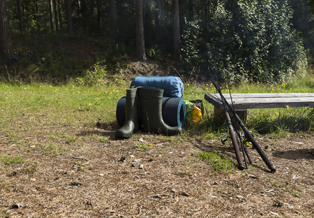 Camping and fishing equipment outdoors and two rodsの写真素材