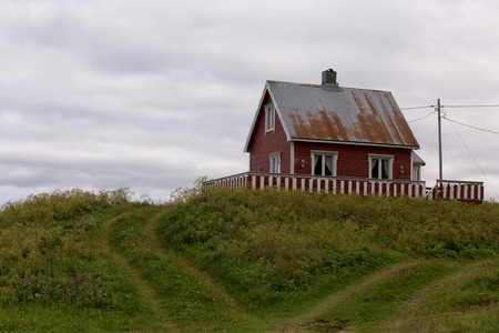 An old house on a hill with heart shaped tracks in front of itの写真素材
