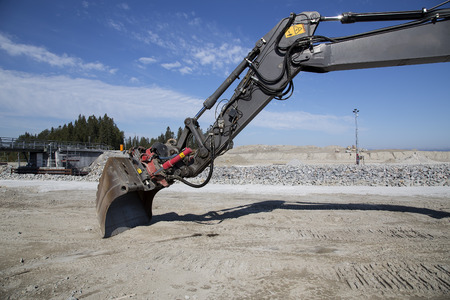 An excavator with a scoop in a construction siteの写真素材