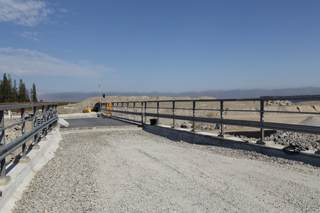 A bridge that is under construction with a sky and some trees in the backgroundの写真素材