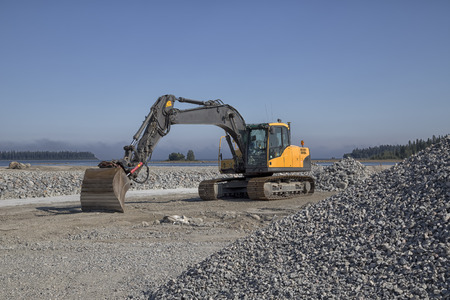 An excavator and a pile of gravelの写真素材