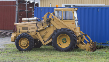 A parked tractor in front of a container
