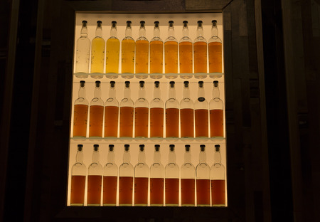 A line of whiskey bottles to show the aging processの写真素材