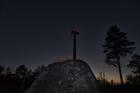 A big stone in the foreground and a colorful sky with stars and the last light from the sun