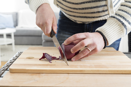 A man cutting onion on a cutting boardの写真素材